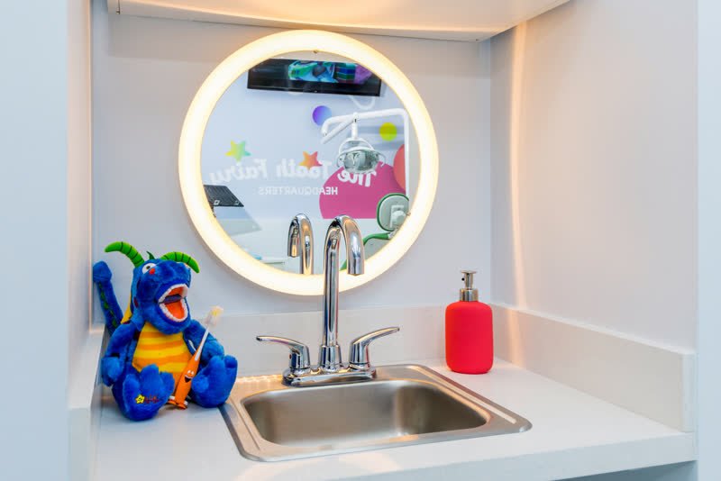 Kids' tooth brushing station with an illuminated mirror at The Tooth Fairy HQ pediatric dentist
