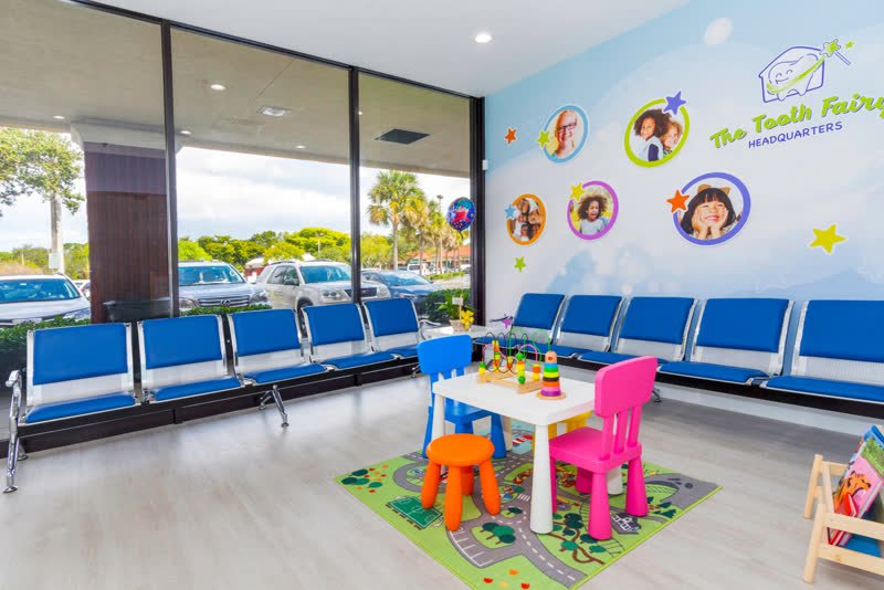 Kid-friendly waiting room with a play table and toys at The Tooth Fairy HQ pediatric dental office in North Lauderdale, FL